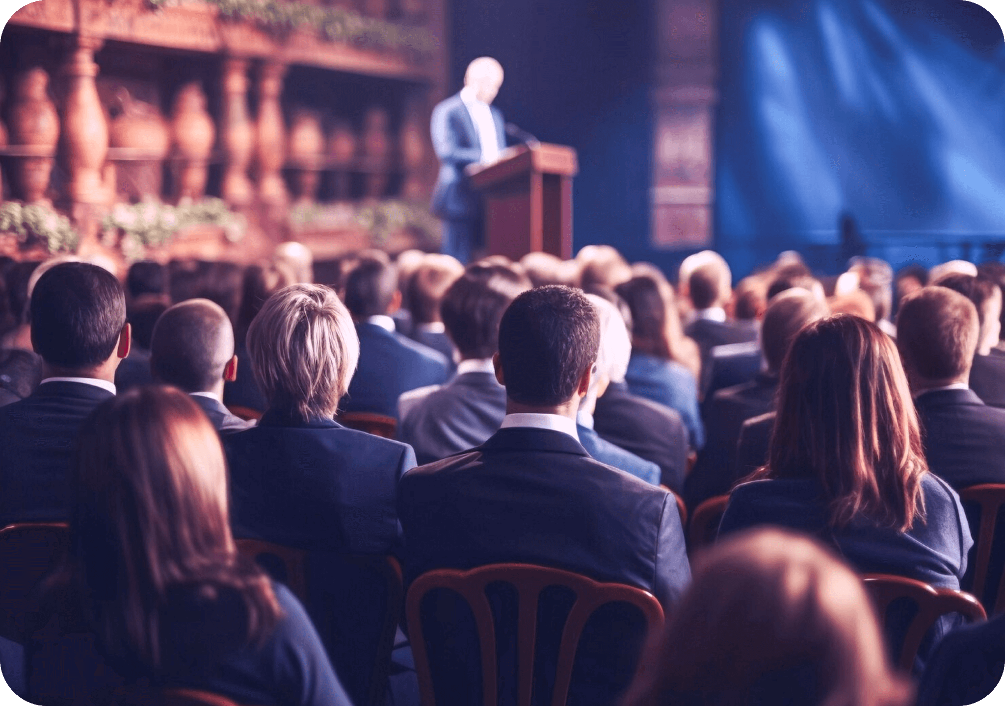 An audience at an auction with a man at the podium